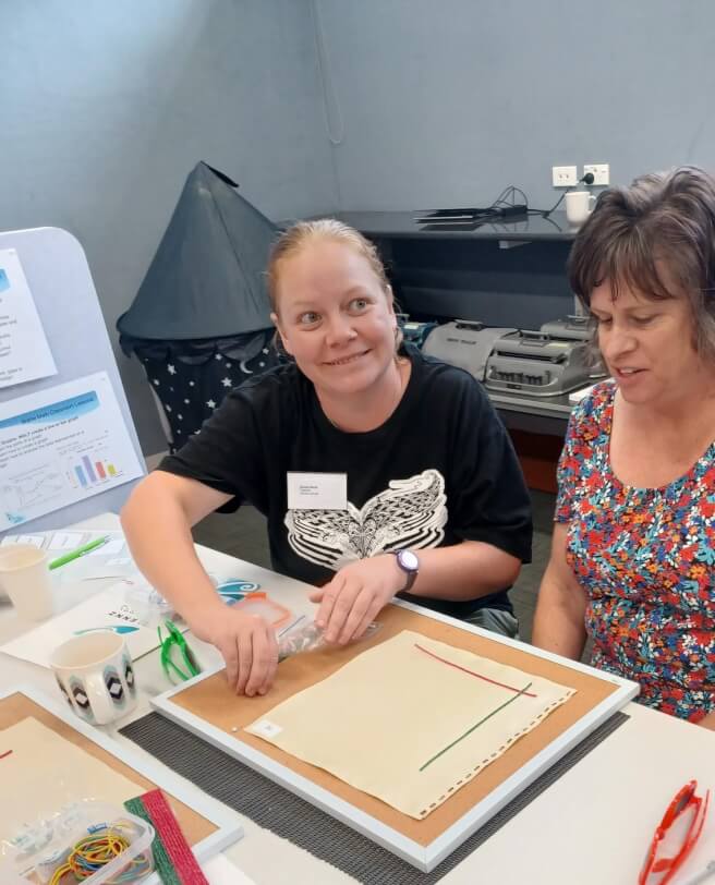 Two people sitting at a table with mapping resources.