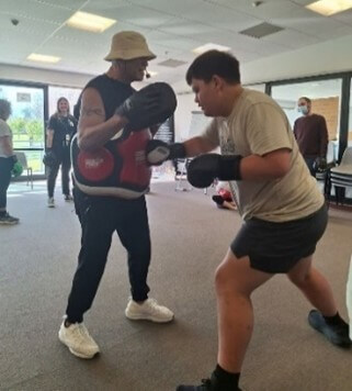Transition staff member and ākonga standing with boxing gloves on doing Boxfit.