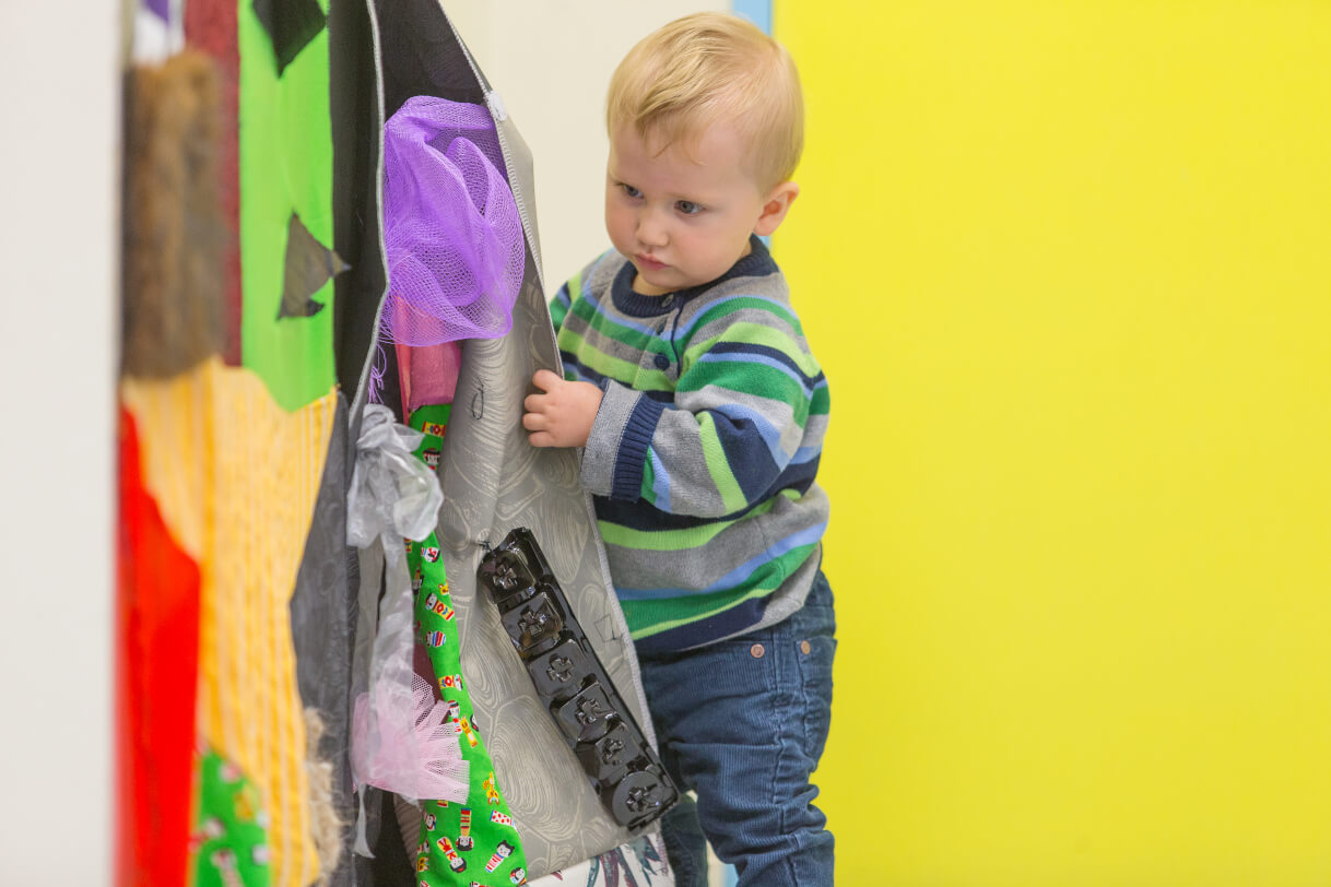 A young boy explores his environment