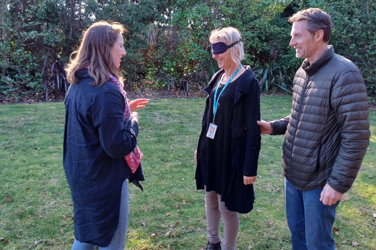 Three Resource Teacher Vision talking while one is guiding another one who is blindfolded