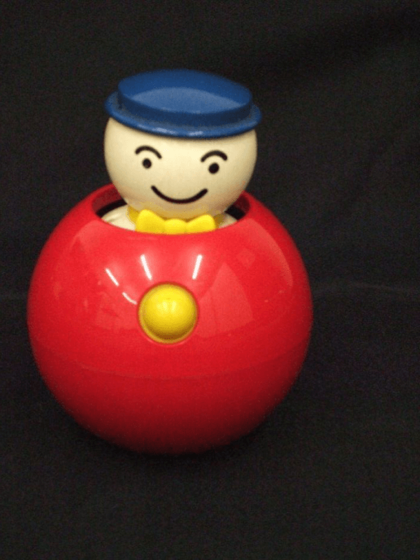 A round plastic ball with a push down figure and a knob to activate.